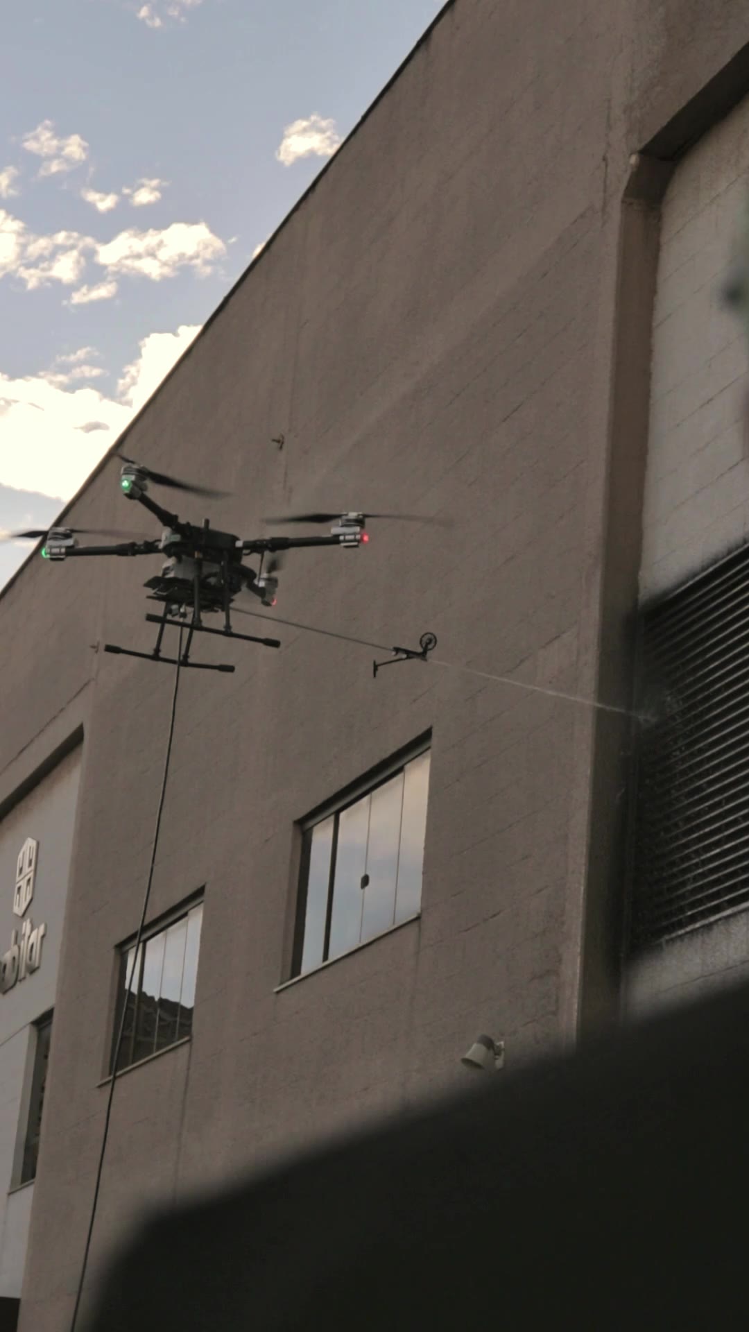 Drone da ALTI em operação de limpeza de fachada envidraçada